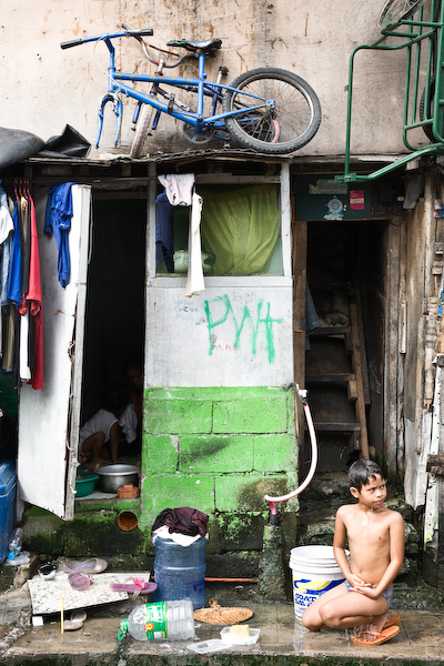 Boy washing. Everything happens on the street here. Makati, Manila